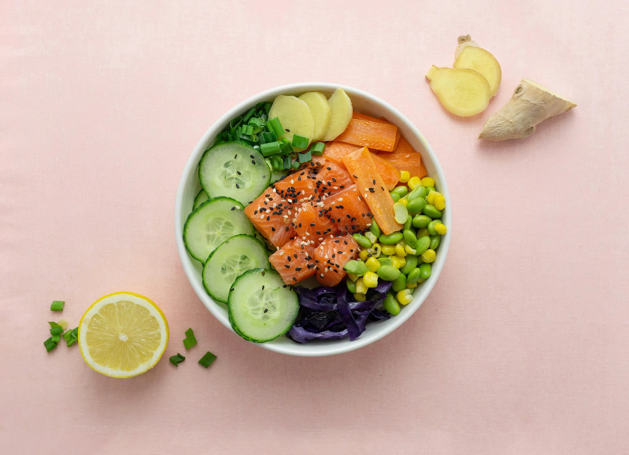A colorful bowl of salmon, cucumbers, carrots, edamame, and ginger, representing a nutrient-dense evening meal to support healthy sleep.